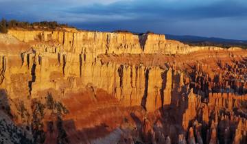Dramatic cliffs with layered rock formations at sunset.