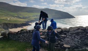 Group of people exploring cliffs by the sea.