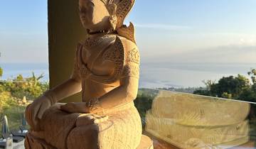 Stone statue with intricate carvings overlooking a view.