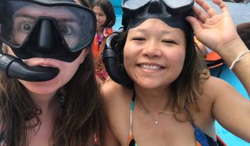 Two friends with snorkeling gear on a boat.