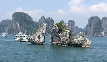 Tourist boat near limestone rocks in Halong Bay.