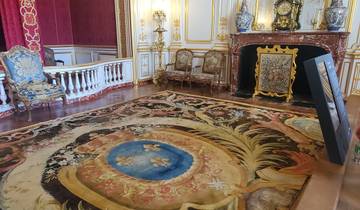 Luxurious interior room with ornate carpet and fireplace.
