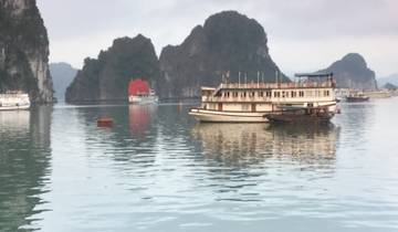 Boat on water with limestone karsts in the background.