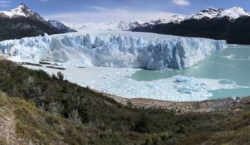 Panoramic view of Perito Moreno Glacier with surrounding mountains and lake.