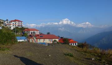 Scenic view of snow-capped mountains and buildings.