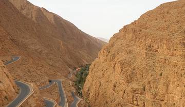 Windy mountain road cutting through a rocky landscape.