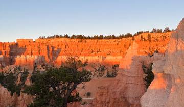 Rock formations with the moon visible in the sky.