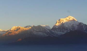 Snow-covered mountains with a clear blue sky.