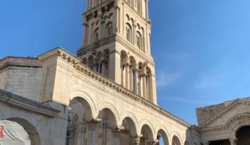 Historic stone tower and arch with tourists.
