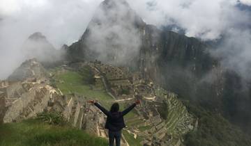 Person with arms raised overlooking Machu Picchu.