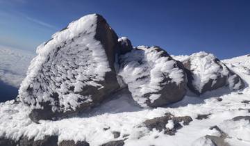 Snow-covered rock formations against a clear sky.