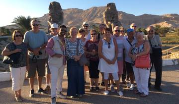 Group of people standing in front of a mountainous landscape.