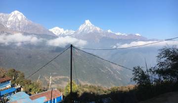 Majestic mountain scenery with rooftops in the foreground.