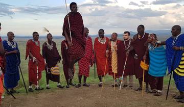 Group of traditionally dressed Maasai men performing a dance.