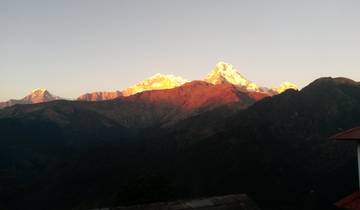Golden sunrise over snow-capped mountains.