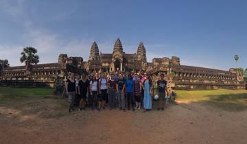 Group of tourists posing in front of a large ancient temple.