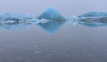 Icebergs floating in a calm lagoon.