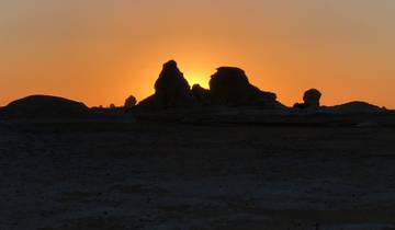 Sunset view with rock formations silhouetted against the sky.