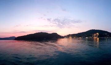 A sunset scene over water with a silhouetted coastline.