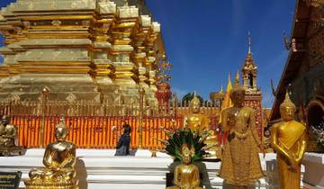 Golden statues and a temple complex under a blue sky.