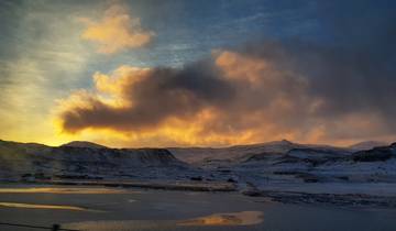Snow-covered landscape with a colorful sunset.