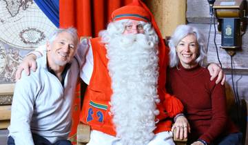 Couple with a figure dressed as Santa in a festive setting.