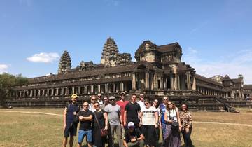 Group of tourists standing in front of the Angkor Wat temple in Cambodia.