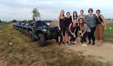 Group of people posing beside ATVs.