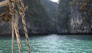 A boat sailing through a narrow passage between limestone cliffs.