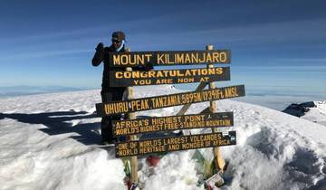 Person celebrating at the summit of Mount Kilimanjaro.