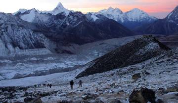 Mountainous landscape with snowy peaks during twilight.