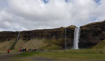 People walking towards a waterfall known as Skogafoss.