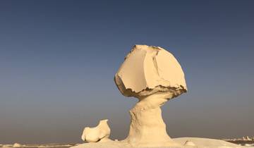 Oddly shaped white rock formations against a clear sky.