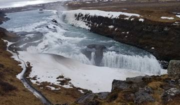 Frozen waterfall surrounded by icy landscape, Iceland.