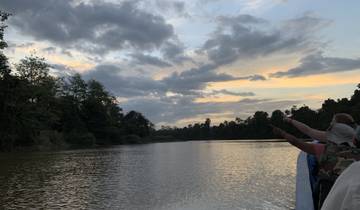 Scenic river view with people pointing towards the water during sunset.