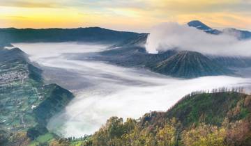 Aerial view of a crater with mist and smoke.