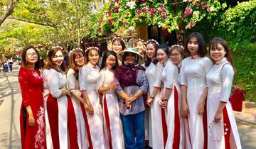 Group of women in traditional attire posing with a visitor.