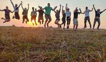 Group of people jumping in the air at sunset.