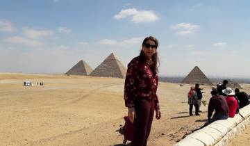 A woman standing in front of the pyramids of Giza.
