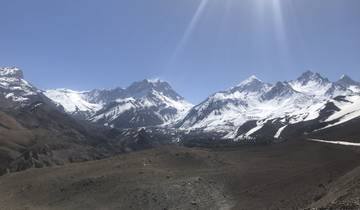 Panoramic view of snow-covered peaks against a blue sky.