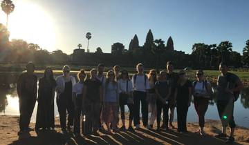 Group of tourists posing in front of Angkor Wat.