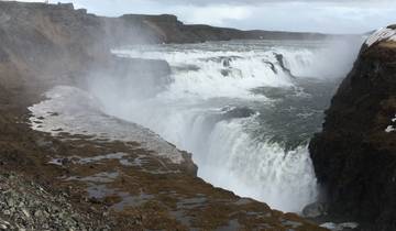 Powerful waterfall with mist and cliffs.