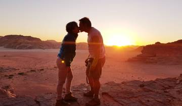 Couple kissing at sunset in the desert.