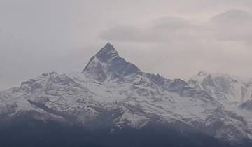 Majestic snow-capped mountains under a cloudy sky.