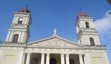 Cathedral facade with large columns under a bright sky.