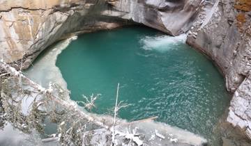 A natural pool with turquoise water surrounded by rocks.