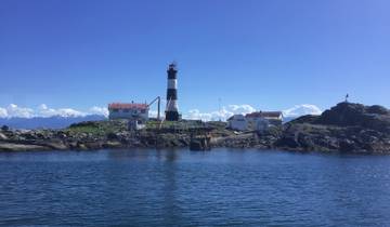 Historic lighthouse and buildings on a rocky island.