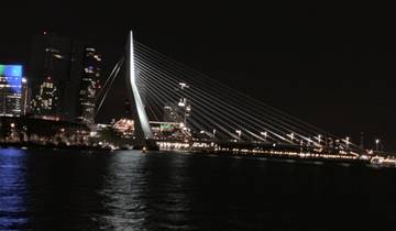 Night view of a bridge and city lights reflecting on the water.