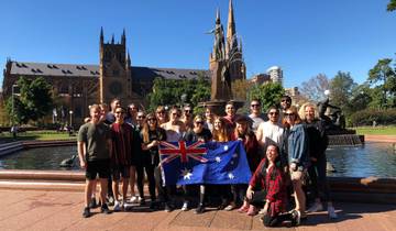 Group of people holding a national flag in front of a cathedral.