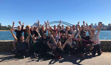 Group of people joyfully posing with the Sydney skyline and bridge in the background.